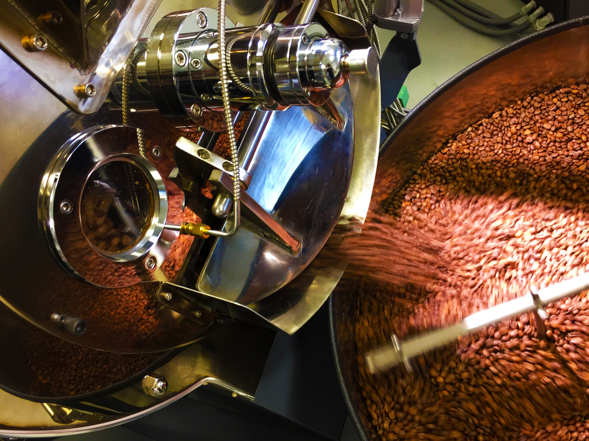 Freshly roasted coffee beans tumbling out of the roaster